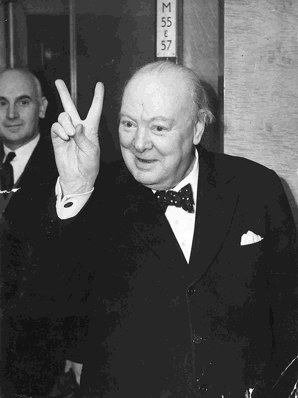 Winston Churchill makes the V-signal while aboard the Cunard liner RMS Queen Mary.