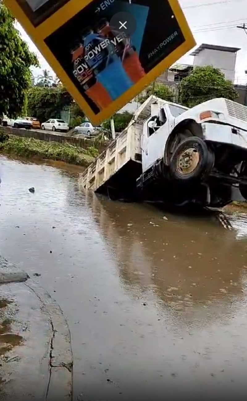 A sinkhole opened up with the rains and sank a cargo truck.