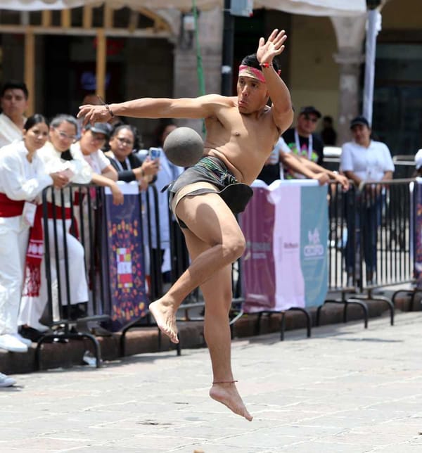A young Zapotec athlete, focused and determined, propels a rubber ball with his hip in a modern Ulama match.