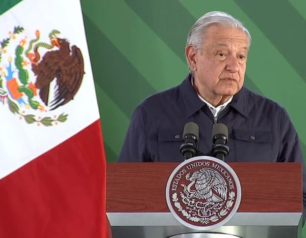 President AMLO stands at a podium, gesturing passionately as he addresses the audience during the conference.
