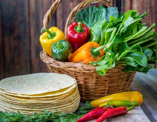 A basket overflowing with colorful vegetables like peppers, onions, and leafy greens.