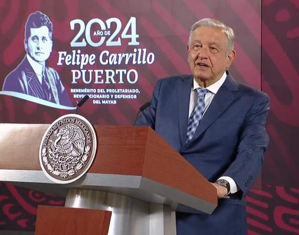 President López Obrador speaks at a podium, gesturing emphatically as he addresses the crowd.