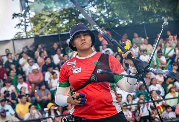 Alejandra Valencia Trujillo, a female archer, holds her bow triumphantly after breaking records.