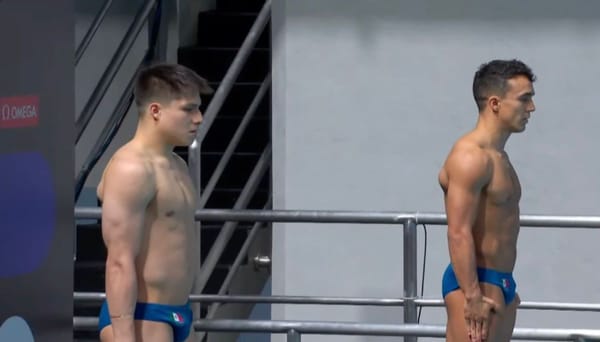 Two Mexican male divers in mid-air during a synchronized diving competition.