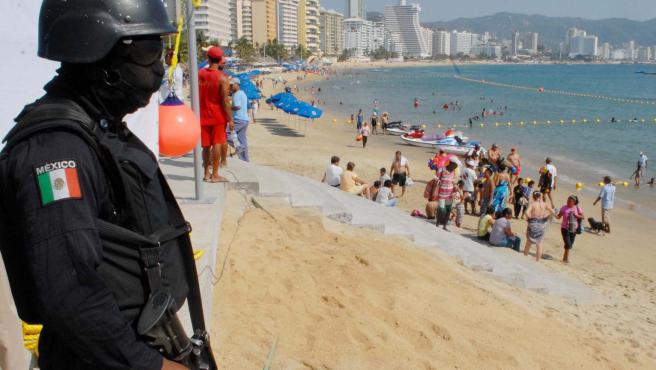 A military man guards a beach in Acapulco, during the Christmas season.