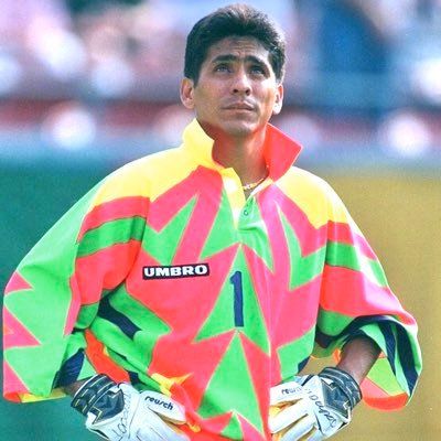 Jorge Campos, the famous Mexican goalkeeper, jumps into action, showing off his bright uniform.