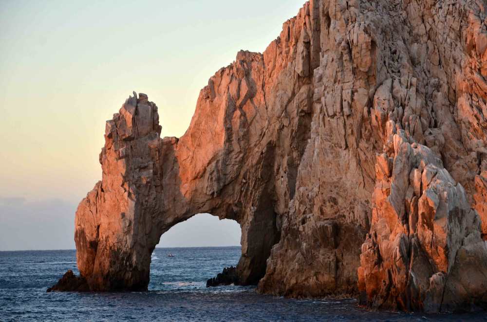 A scenic view of the iconic El Arco rock formation at Land's End in Cabo San Lucas, a popular tourist destination.
