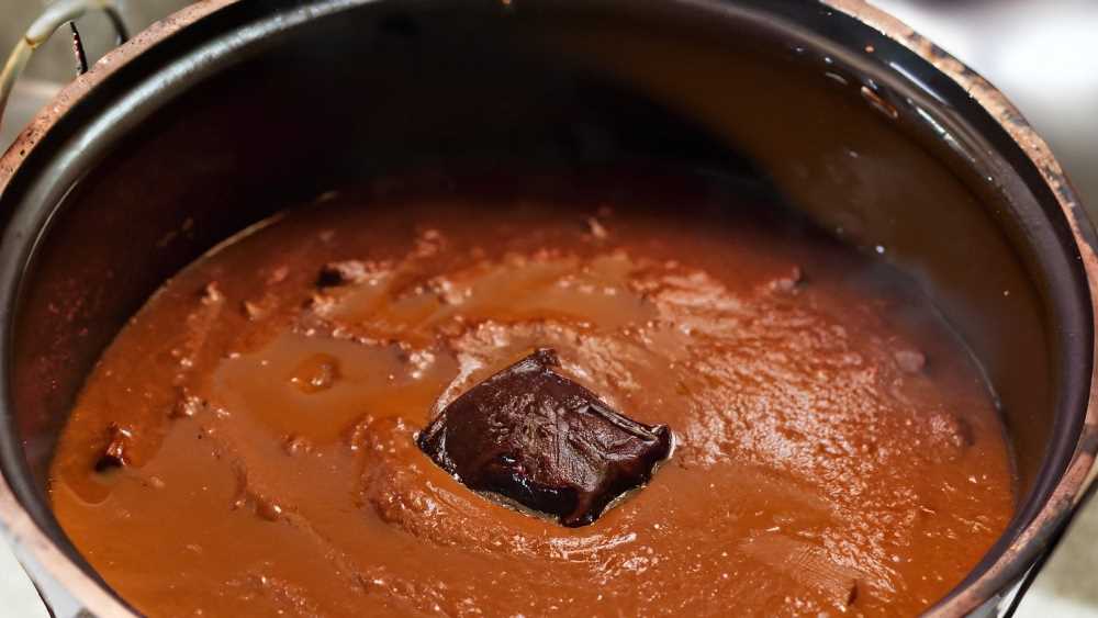 A simmering pot of traditional mole, as indicated by the low, bubbling sound it emits.