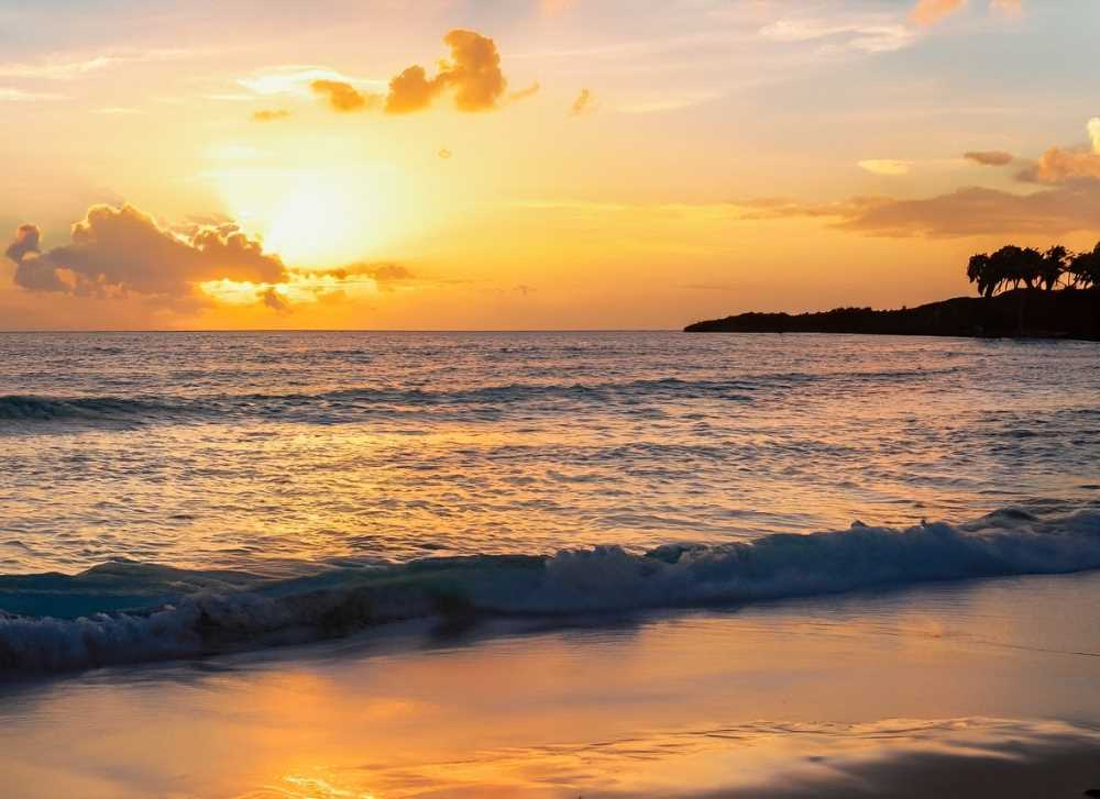 Golden hues paint the sky as the waves gently kiss the shores of Tulum.