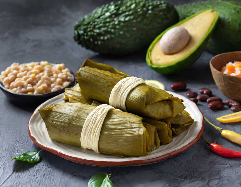 Savor the flavors of tradition with a twist – acoyote bean and corn tamales, wrapped in avocado leaves.
